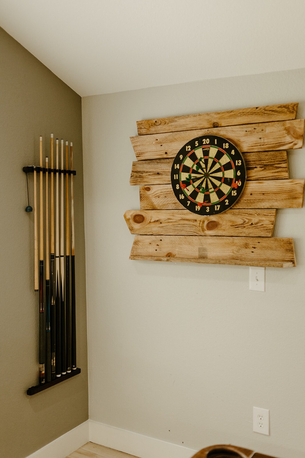 Dart board and pool cues in the game area