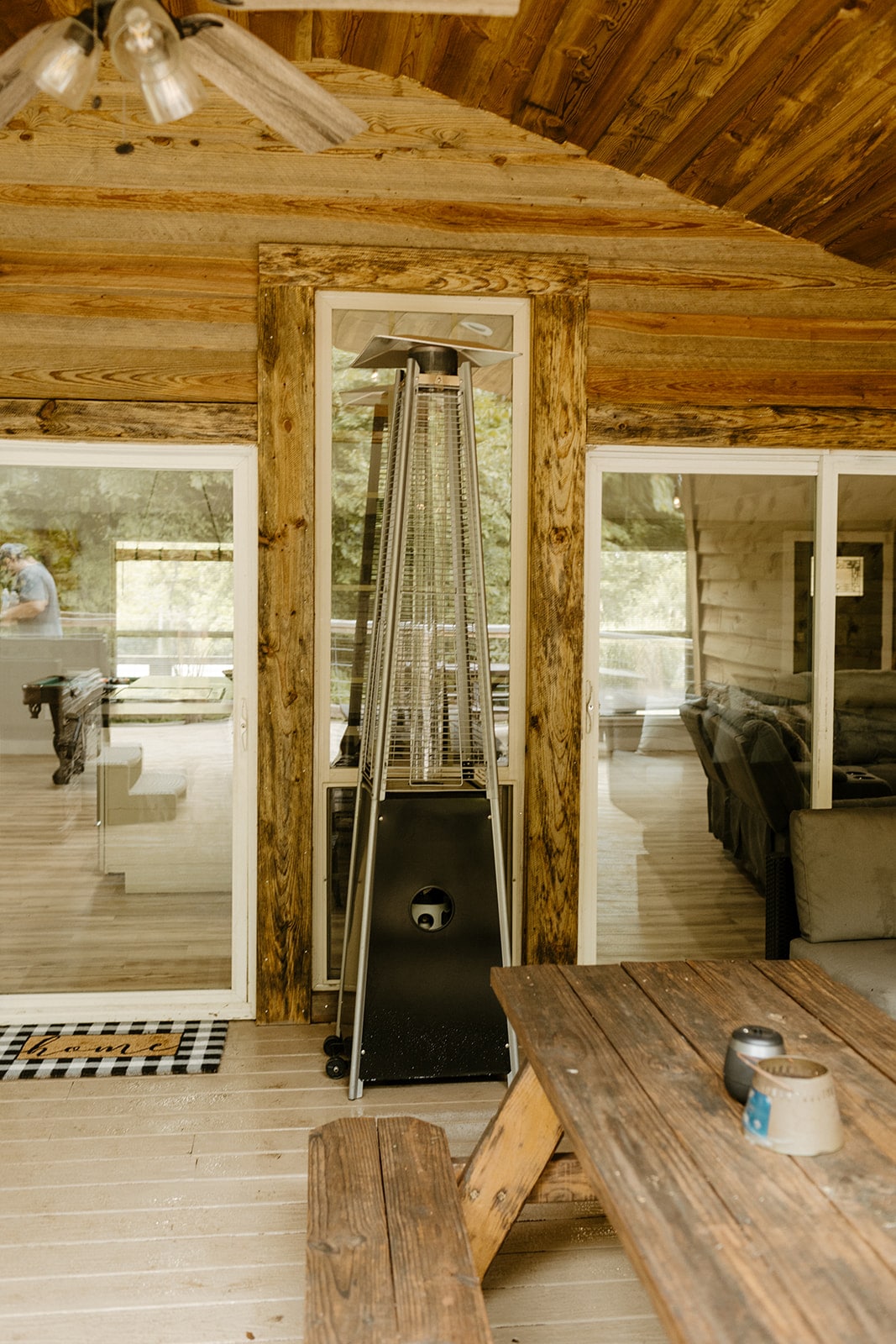 Covered porch entry with outdoor heater and wood siding