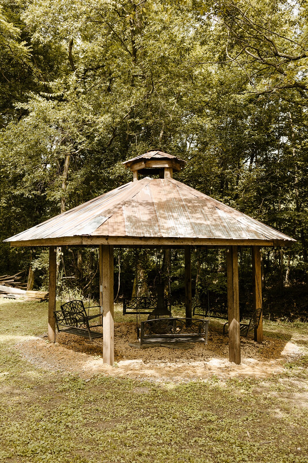 Gazebo seating area under trees near the cabins