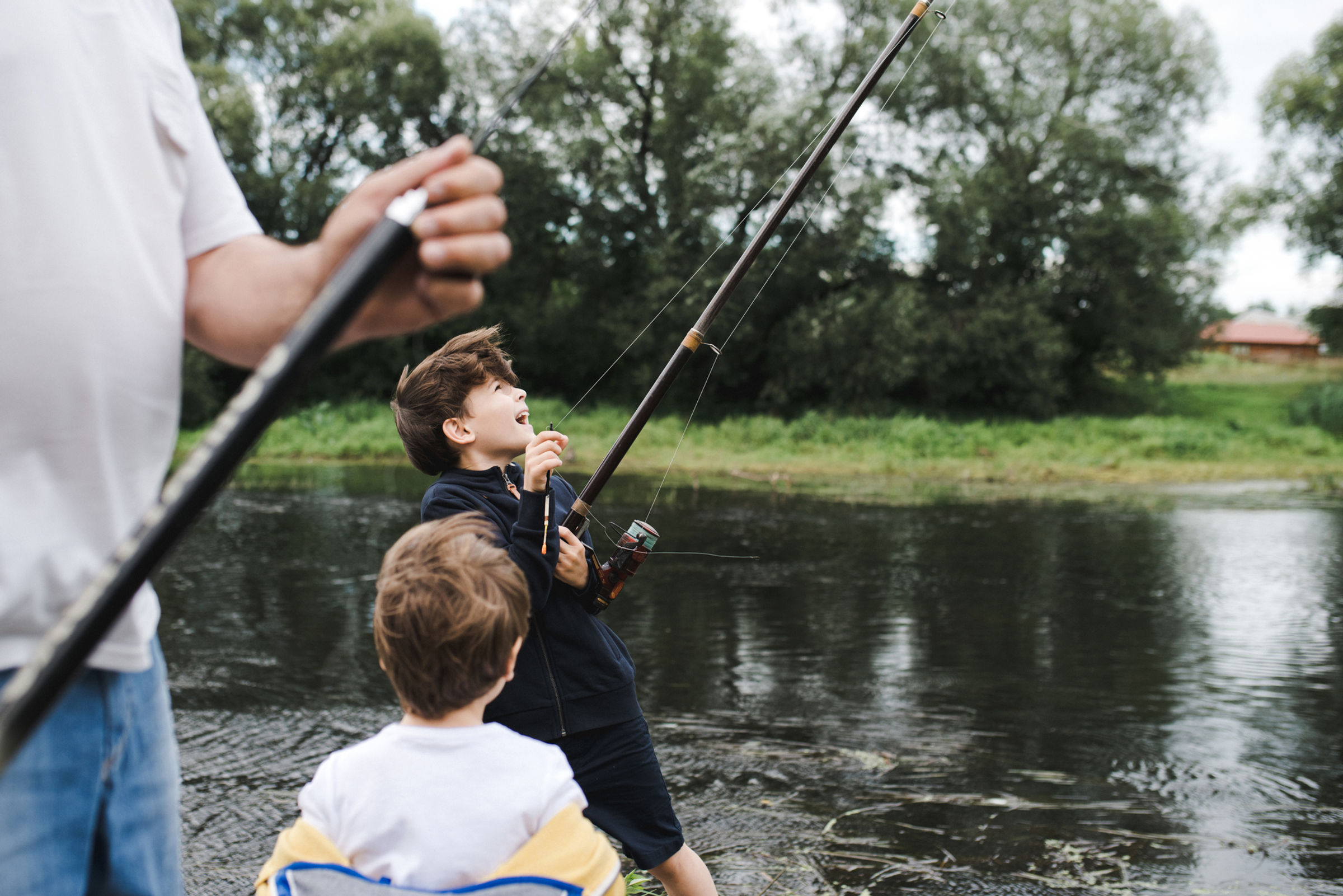 Family fishing beside a calm river